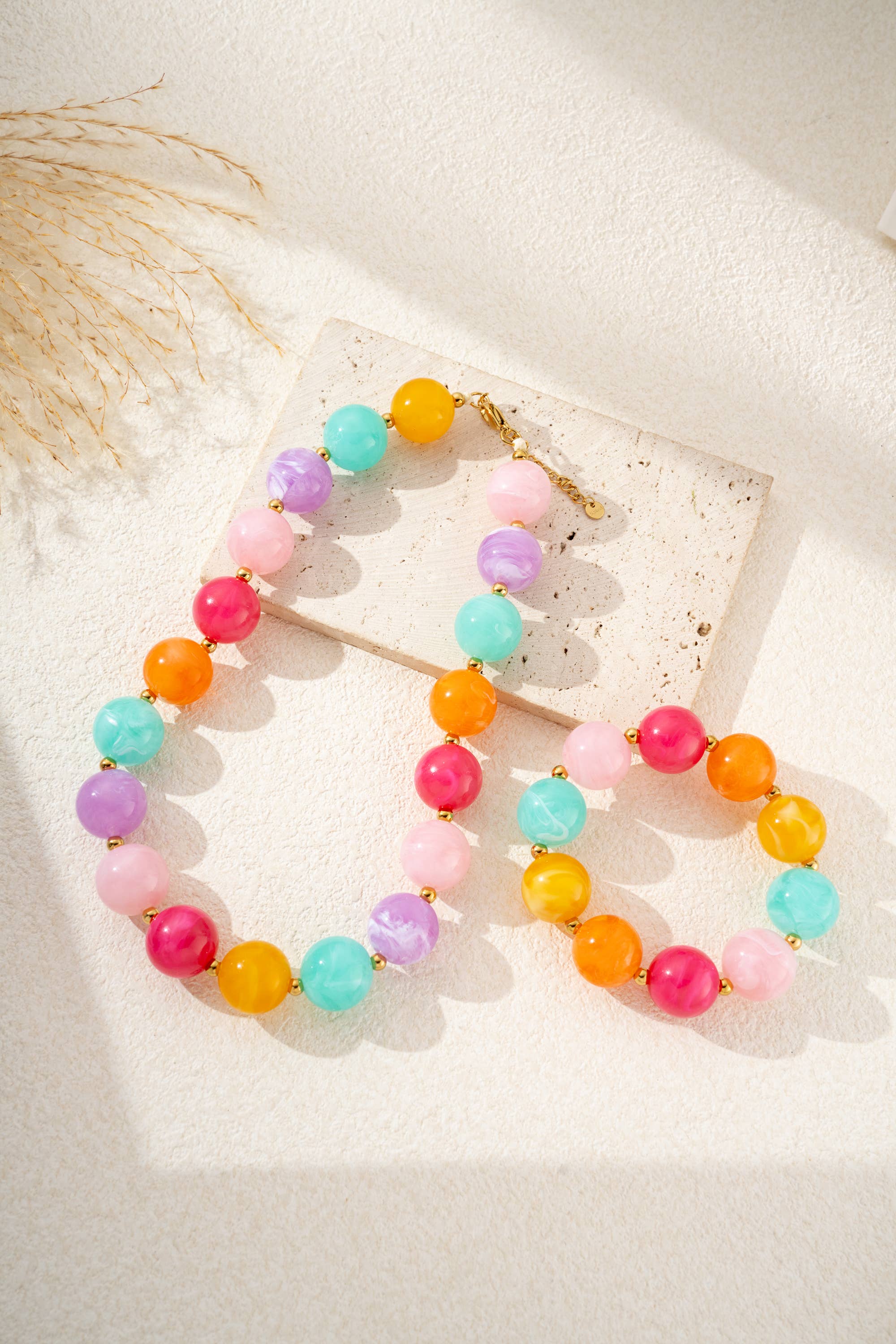 Damesketting met gouden, ronde, gemarmerde gekleurde harskralen