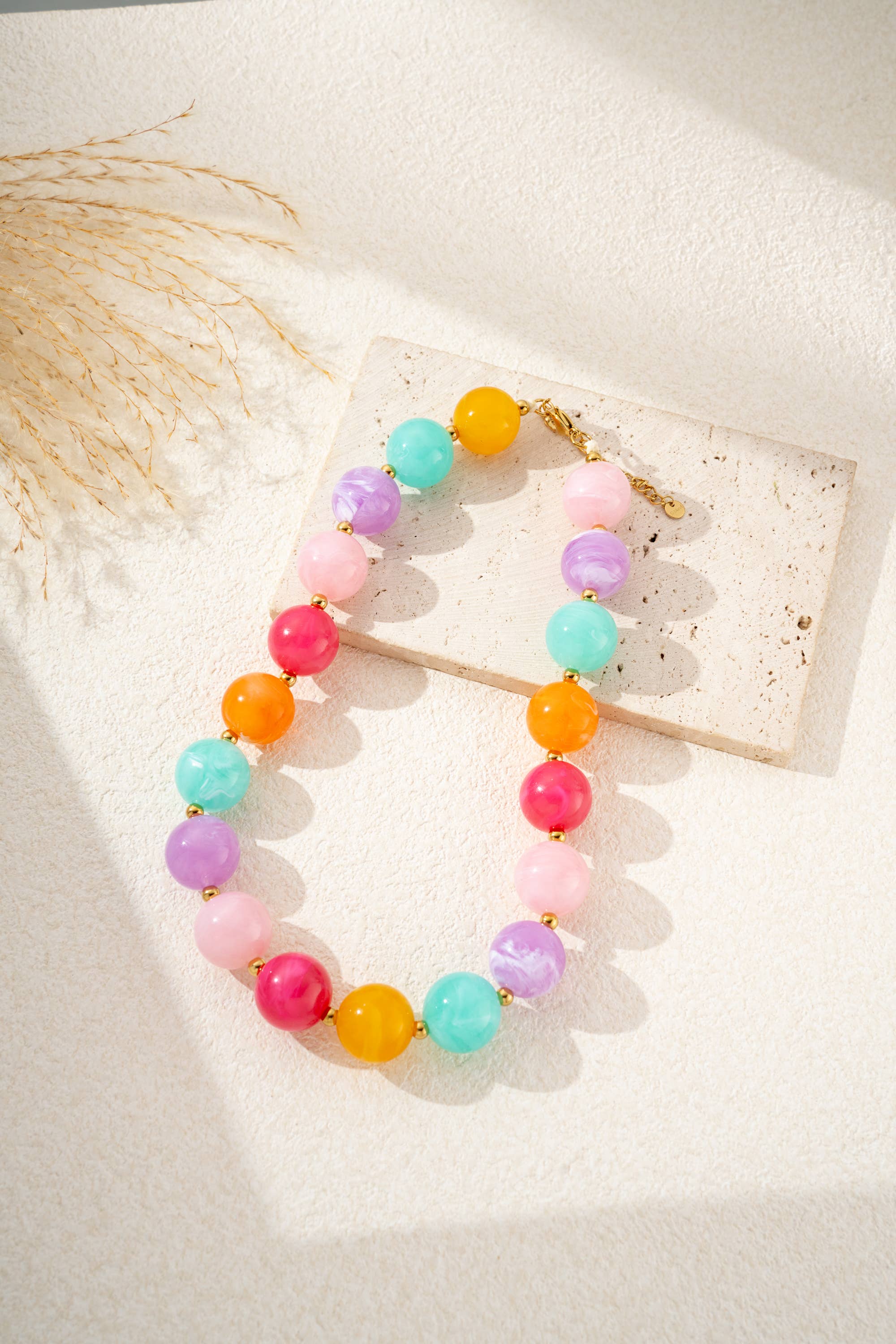 Damesketting met gouden, ronde, gemarmerde gekleurde harskralen