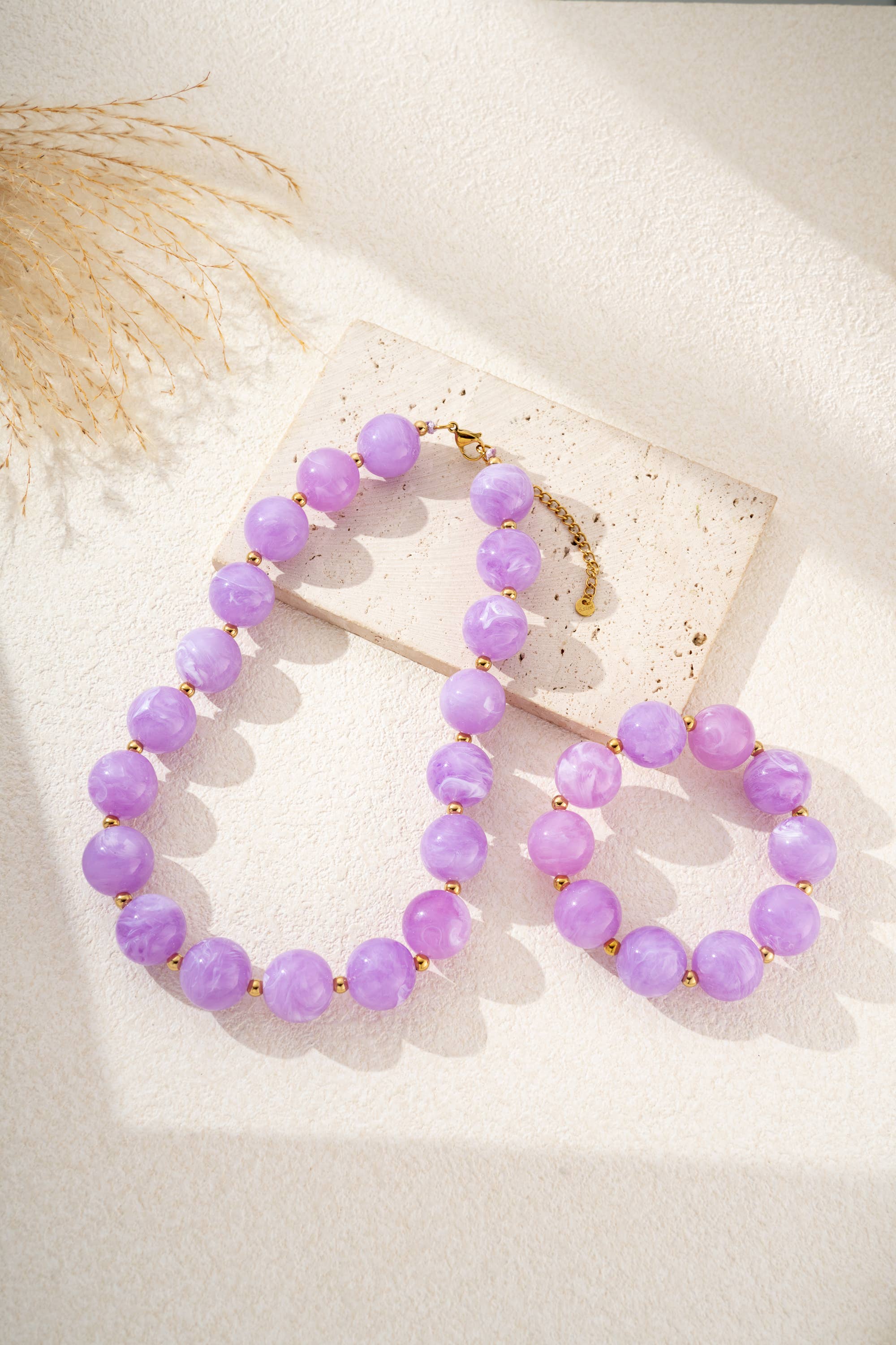 Damesketting met gouden, ronde, gemarmerde gekleurde harskralen