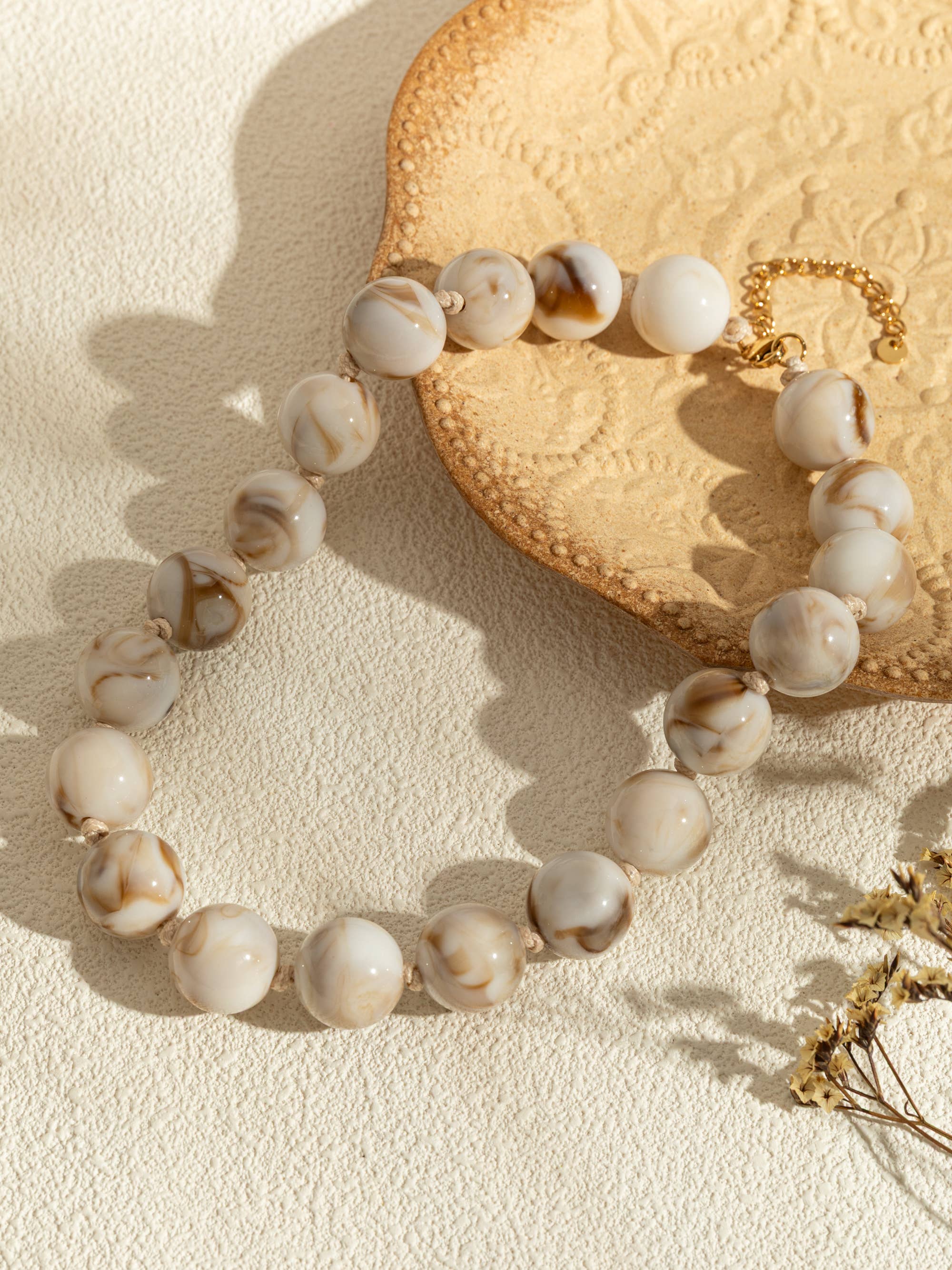 Ronde parelkettingen van gekleurde hars en elegante gouden ketting