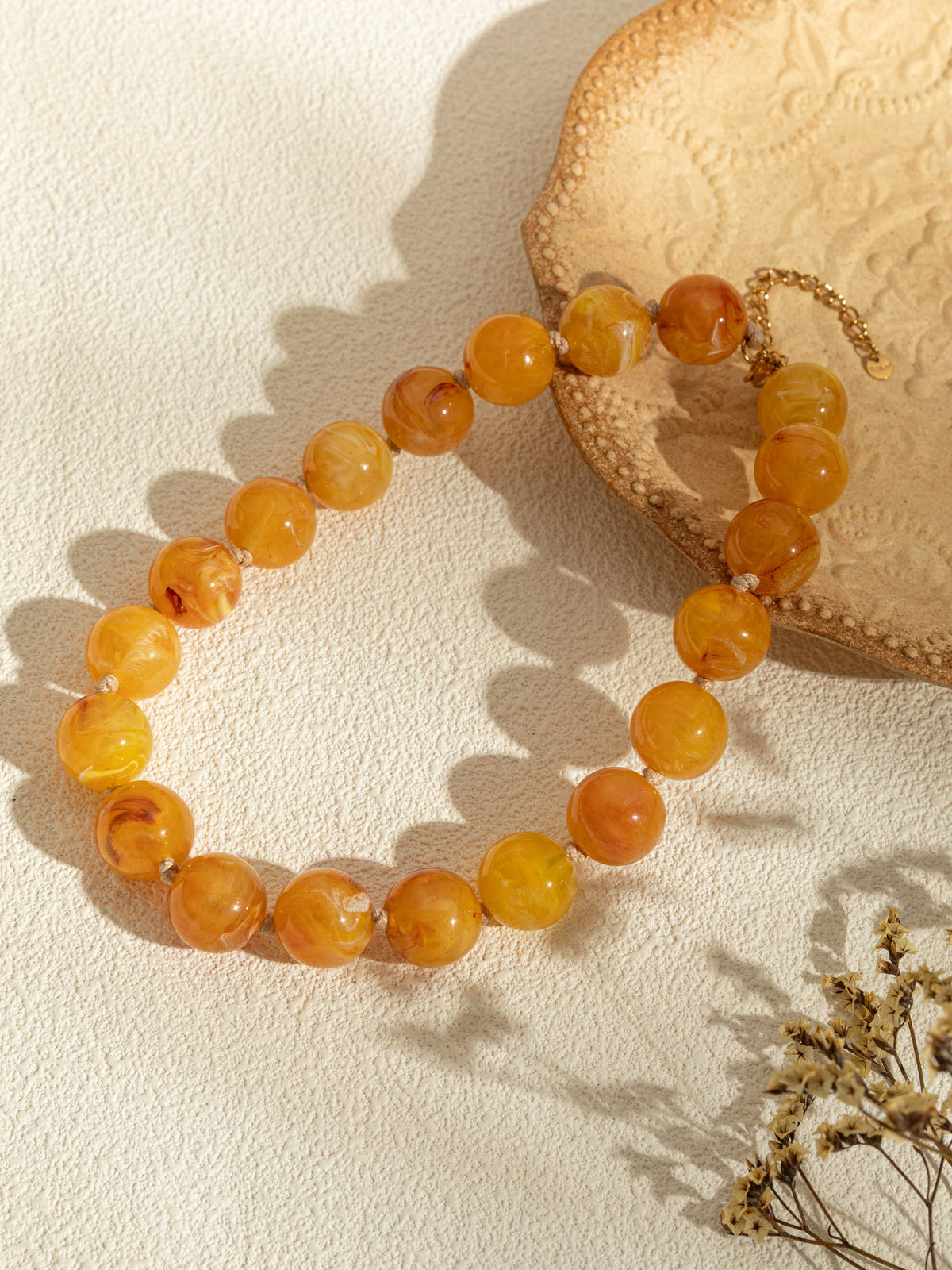 Ronde parelkettingen van gekleurde hars en elegante gouden ketting