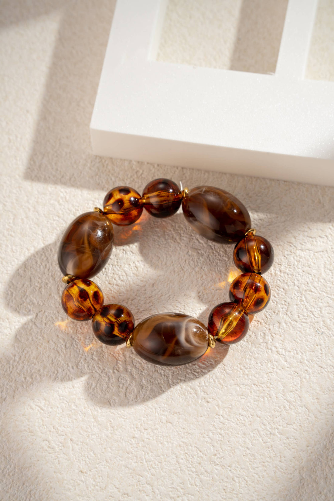 Elastische armband met luipaard- en chocoladeresin kralen en staal