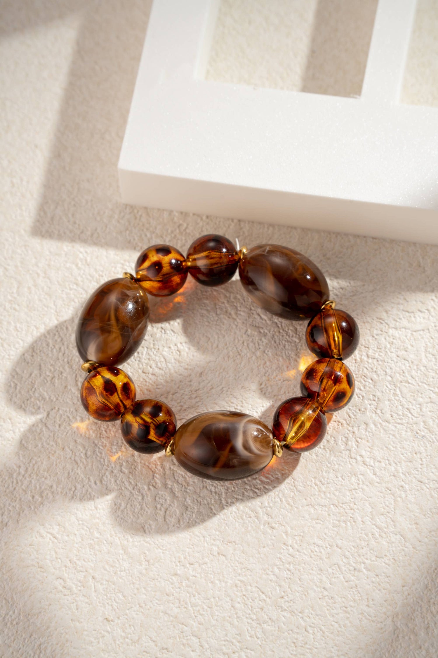 Elastische armband met luipaard- en chocoladeresin kralen en staal