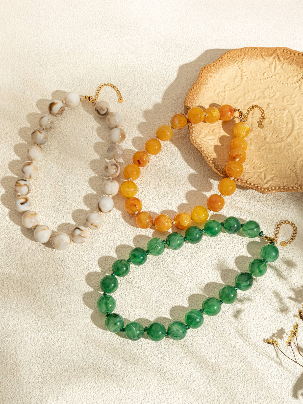 Ronde parelkettingen van gekleurde hars en elegante gouden ketting