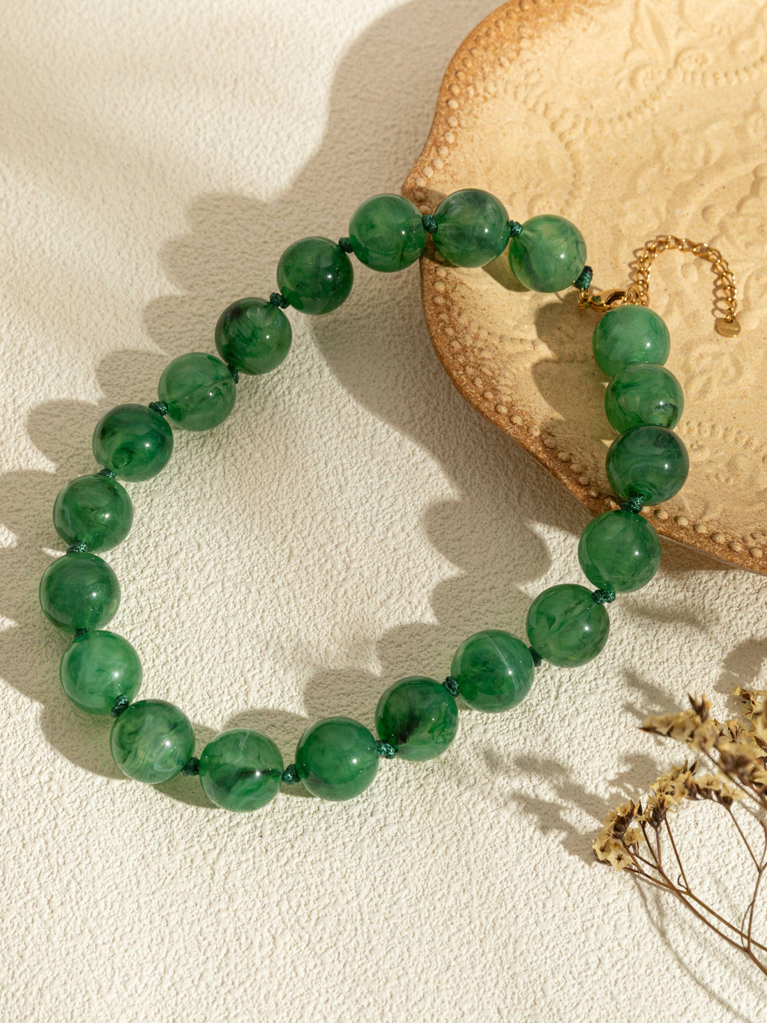 Ronde parelkettingen van gekleurde hars en elegante gouden ketting