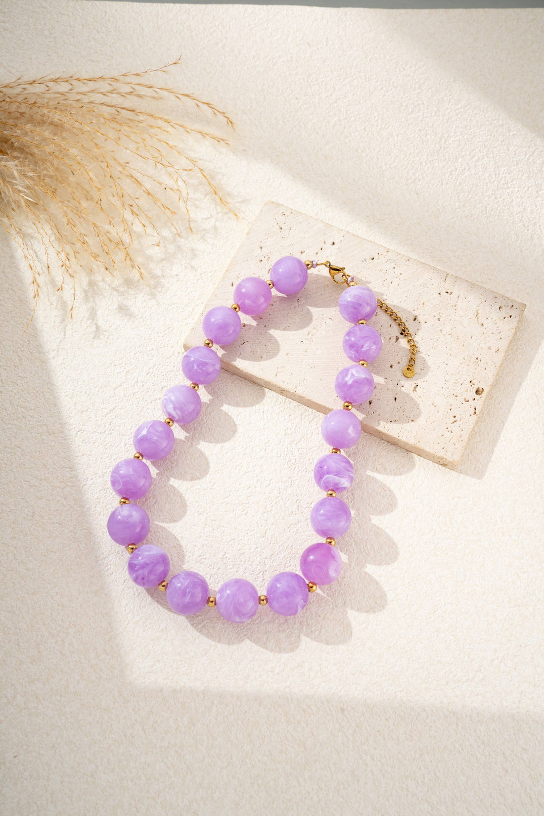 Damesketting met gouden, ronde, gemarmerde gekleurde harskralen