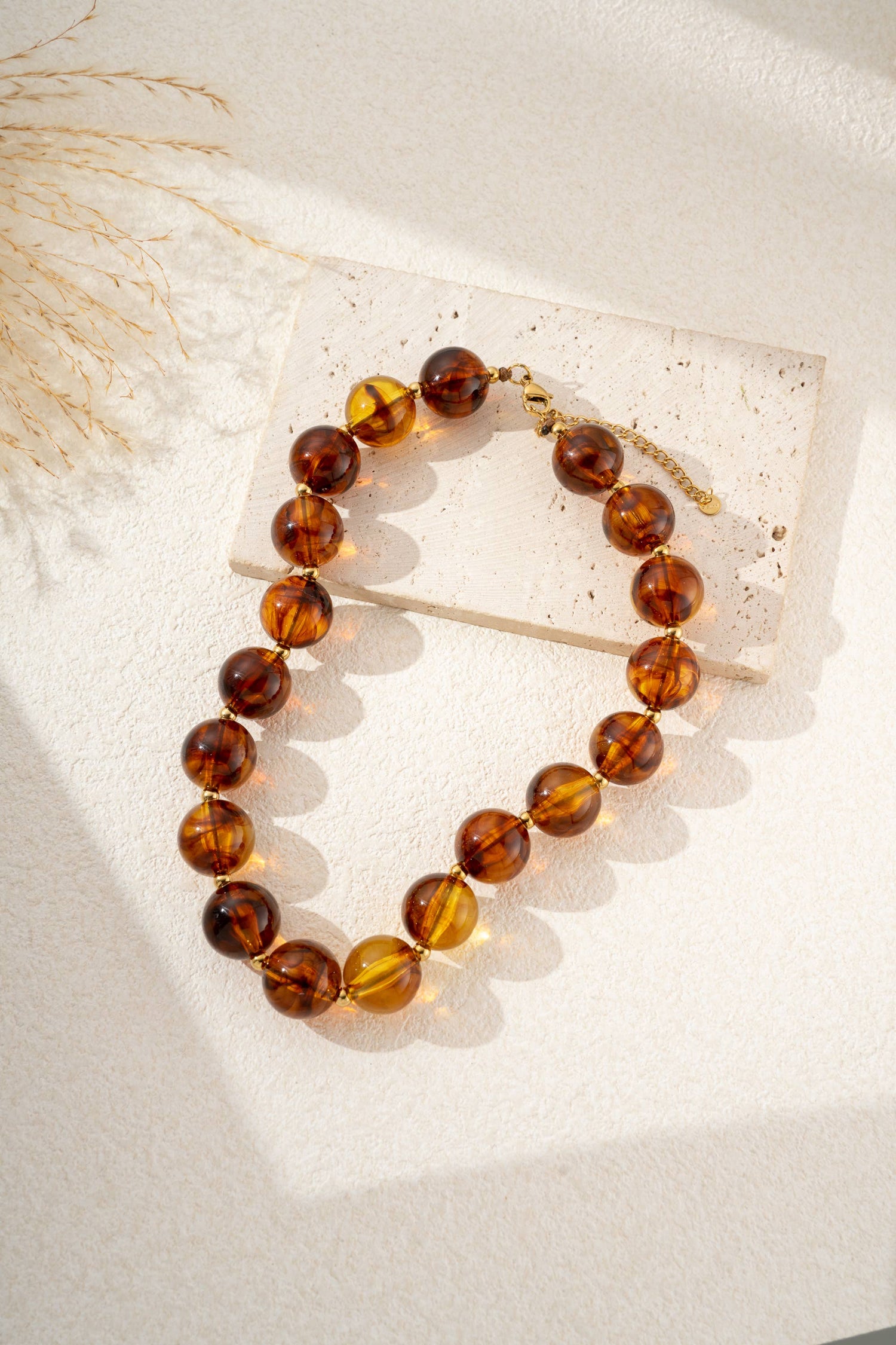 Damesketting met gouden, ronde, gemarmerde gekleurde harskralen
