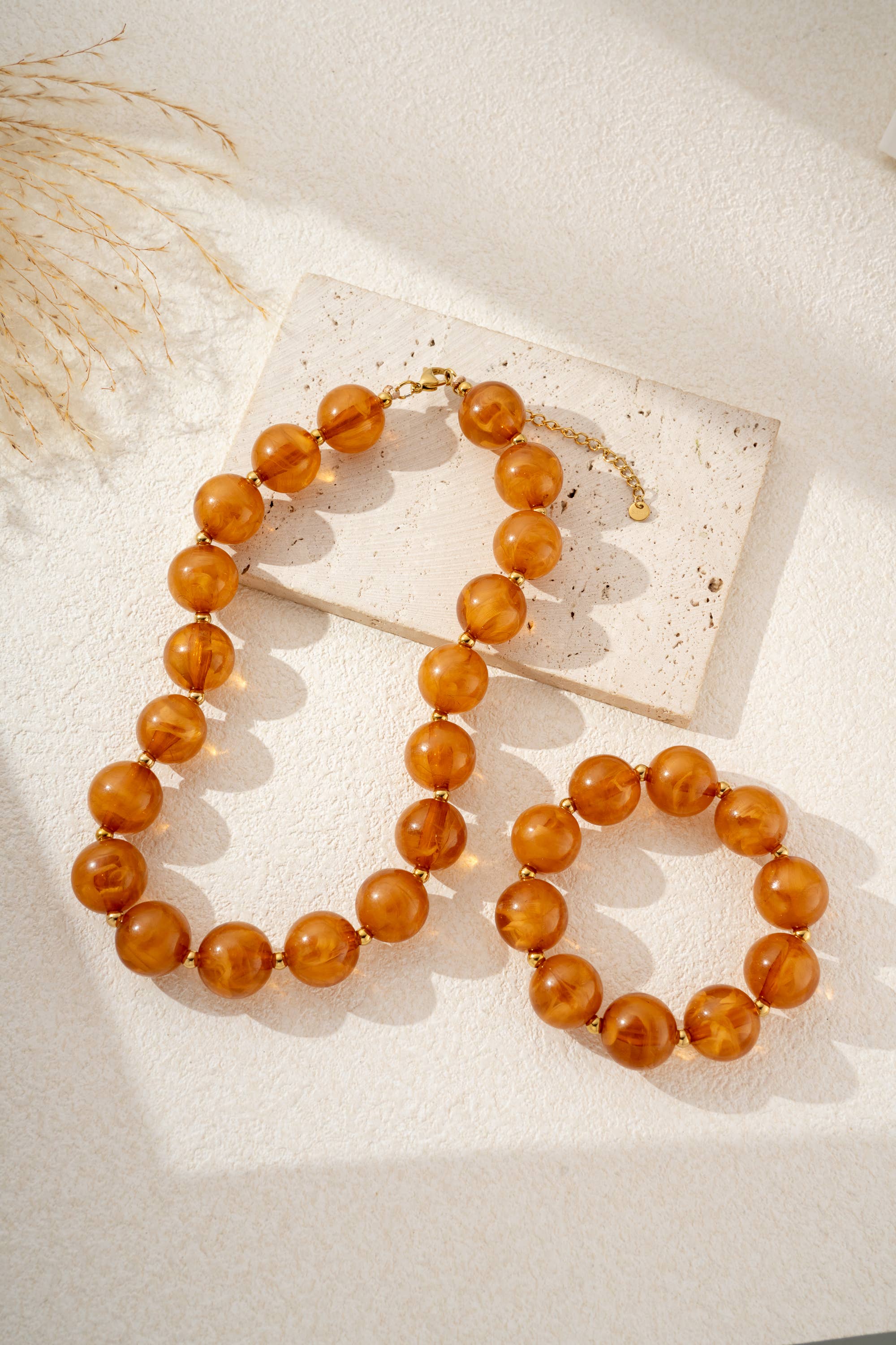Damesketting met gouden, ronde, gemarmerde gekleurde harskralen