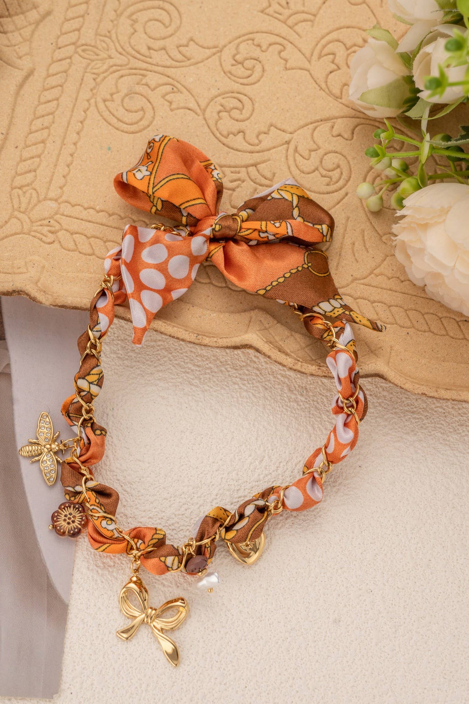 Gevlochten oranje sjaalketting met roestvrijstalen bedels